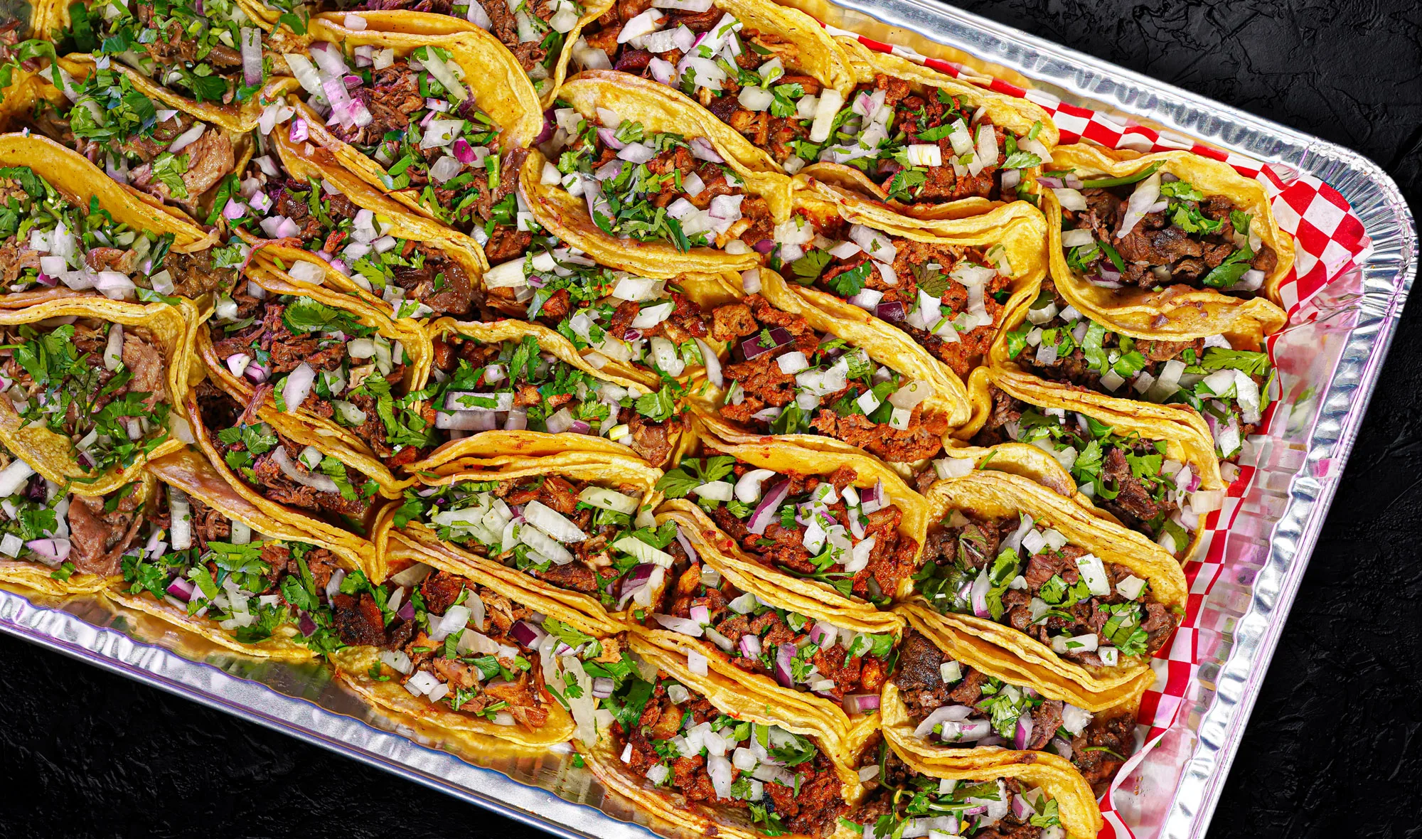 Tray of street tacos with onion and cilantro for catering by Delicias Factory in Branson, MO